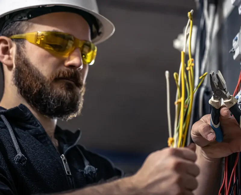 male-electrician-works-switchboard-with-electrical-connecting-cable.webp